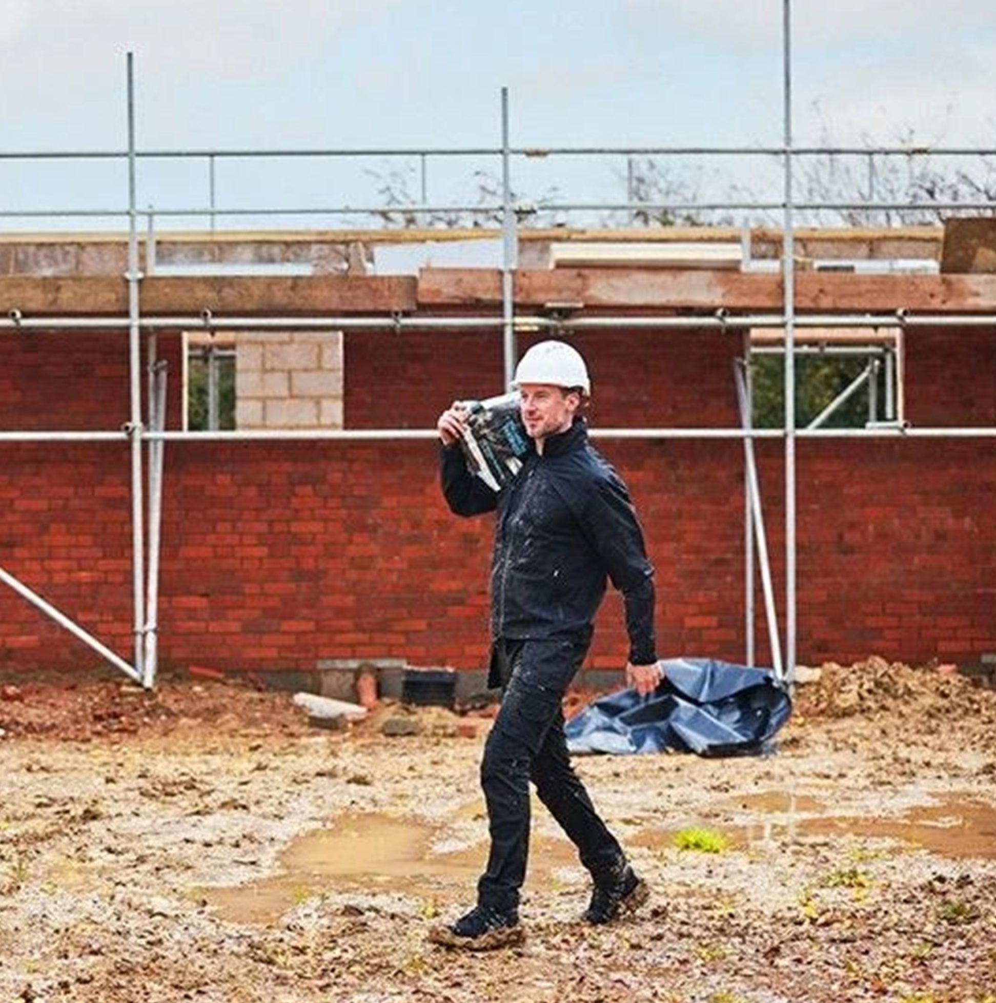 Apache ARMSTRONG Unisex Boots Black worn by a worker on a construction site, showcasing safety and style.