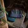 Barbour HARRAY Mens Beanie Green Loch front view, showcasing patterned design and logo-embossed badge on a woven chair.