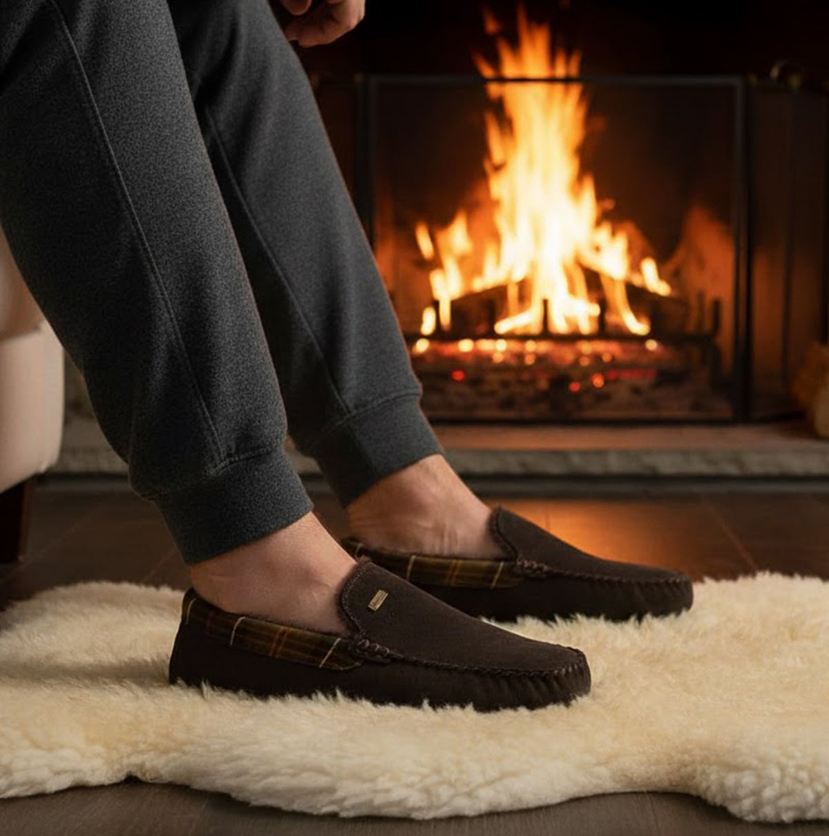 Barbour MONTY Mens Slippers Brown side view worn by a person near a fireplace on a soft rug.