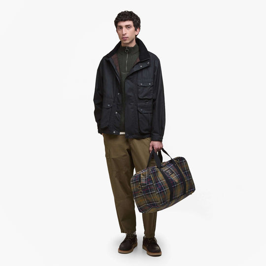 Barbour TORRIDON TARTAN Holdall Bag Classic Tartan front view with model, showcasing classic tartan design and zipper closure.