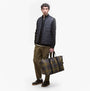 Barbour TORRIDON TARTAN Carry All Bag Classic Tartan front view held by a model, showcasing the classic tartan design.