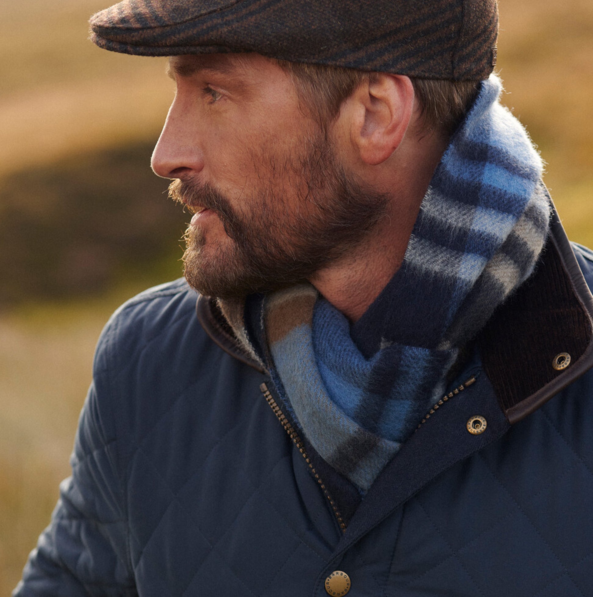 Barbour FIELD REVERSIBLE Scarf Unisex Adults Navy side view on model, showcasing premium lambswool and check design.