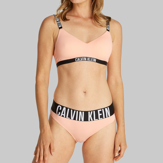 Calvin Klein INTENSE POWER Womens Bikini Briefs Papaya Punch side view on model wearing matching bralette.