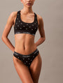 Calvin Klein MODERN COTTON Womens Thong Black Diamond Logo Print side view on model wearing black bralette and thong set.