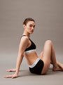 Calvin Klein MODERN COTTON High Waisted Boxers Womens Black side view model sitting, showcasing CK signature elastic waistband.