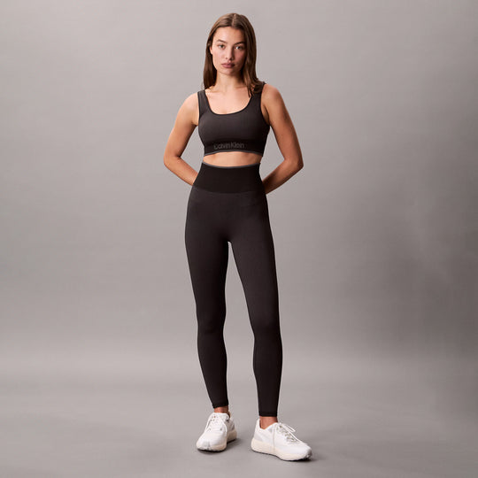 Calvin Klein Medium Impact Sports Bra front view in black, showcasing a stylish design with matching leggings.