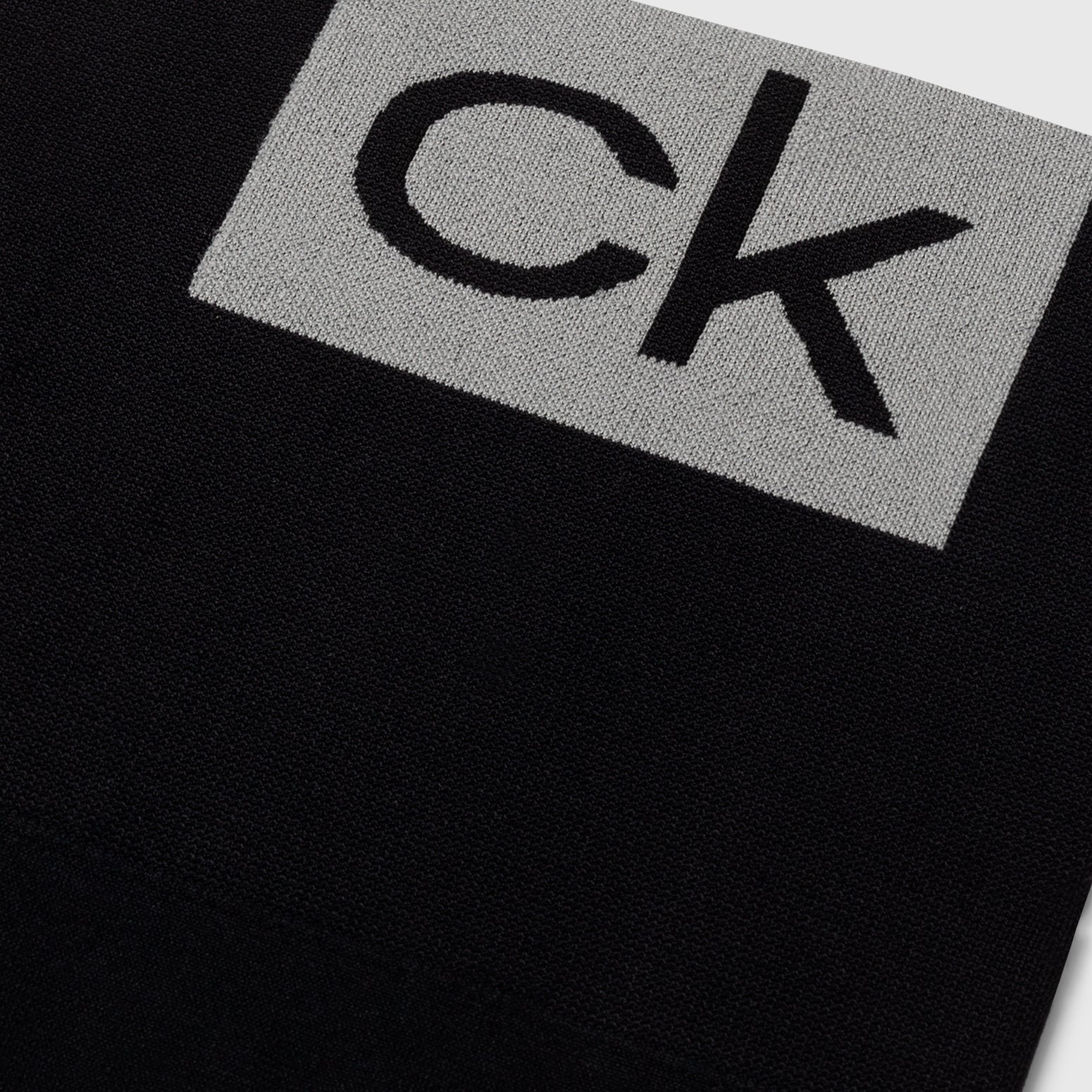 Calvin Klein LOGO Gym Leggings Black detail view of CK logo on fabric, showcasing sleek design and quality material.