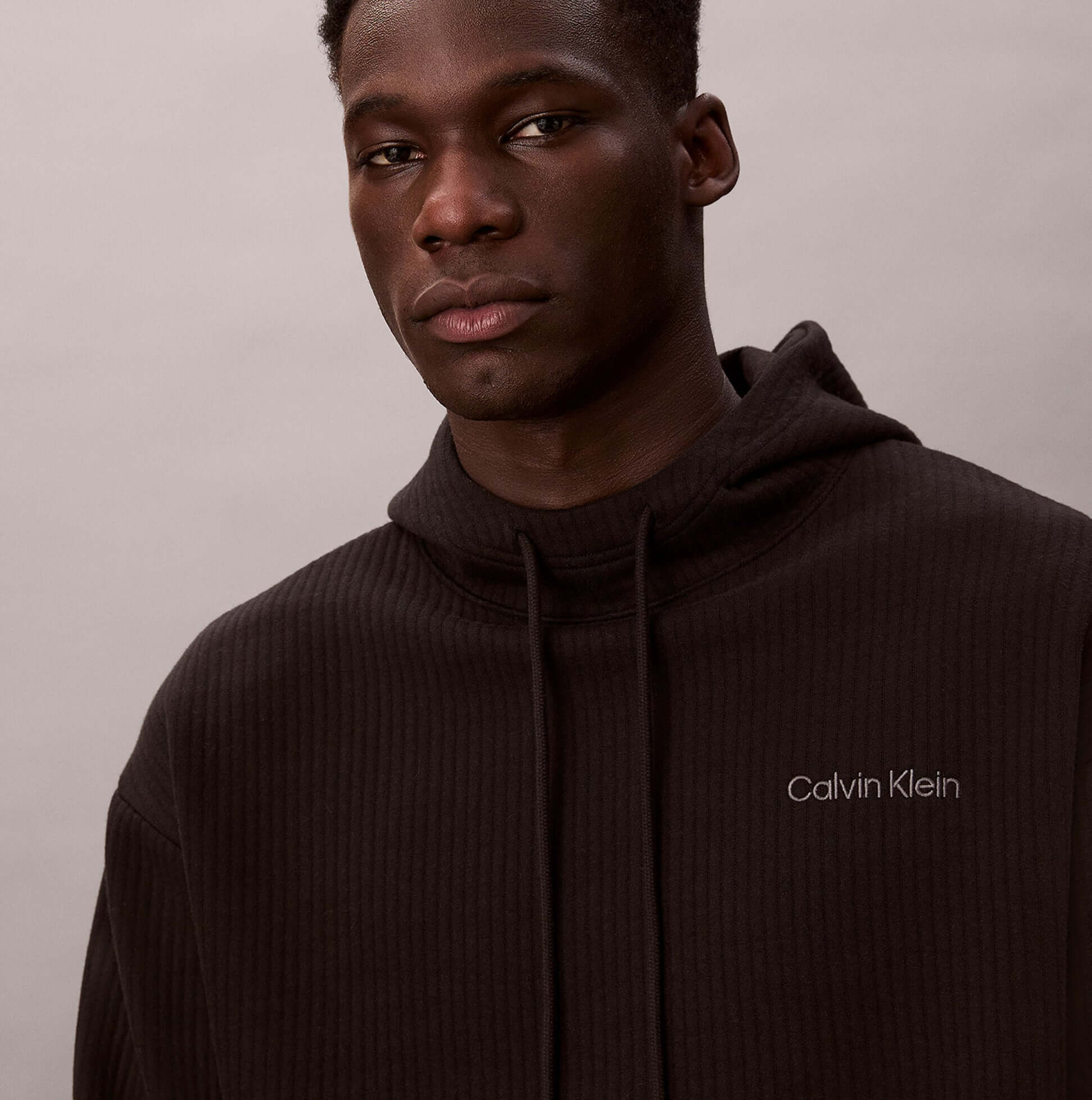 Calvin Klein QUILTED HOODIE Mens Hoodies Black front view model wearing black hoodie featuring logo detail.