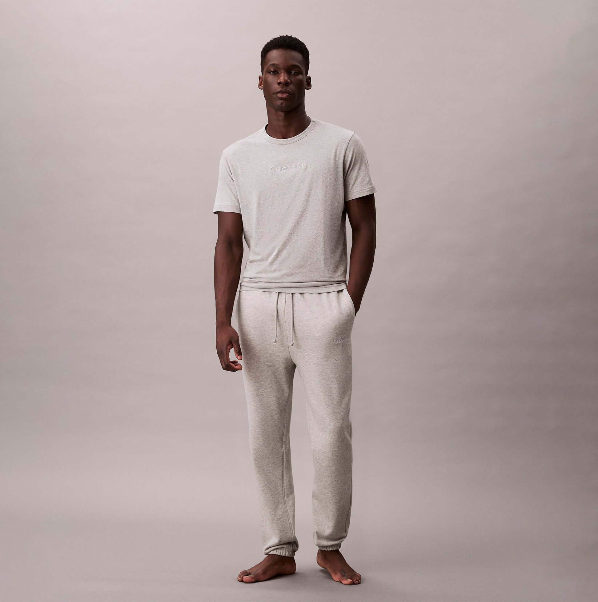 Calvin Klein JOGGER Mens Grey Heather front view model wearing joggers and t-shirt on neutral background.