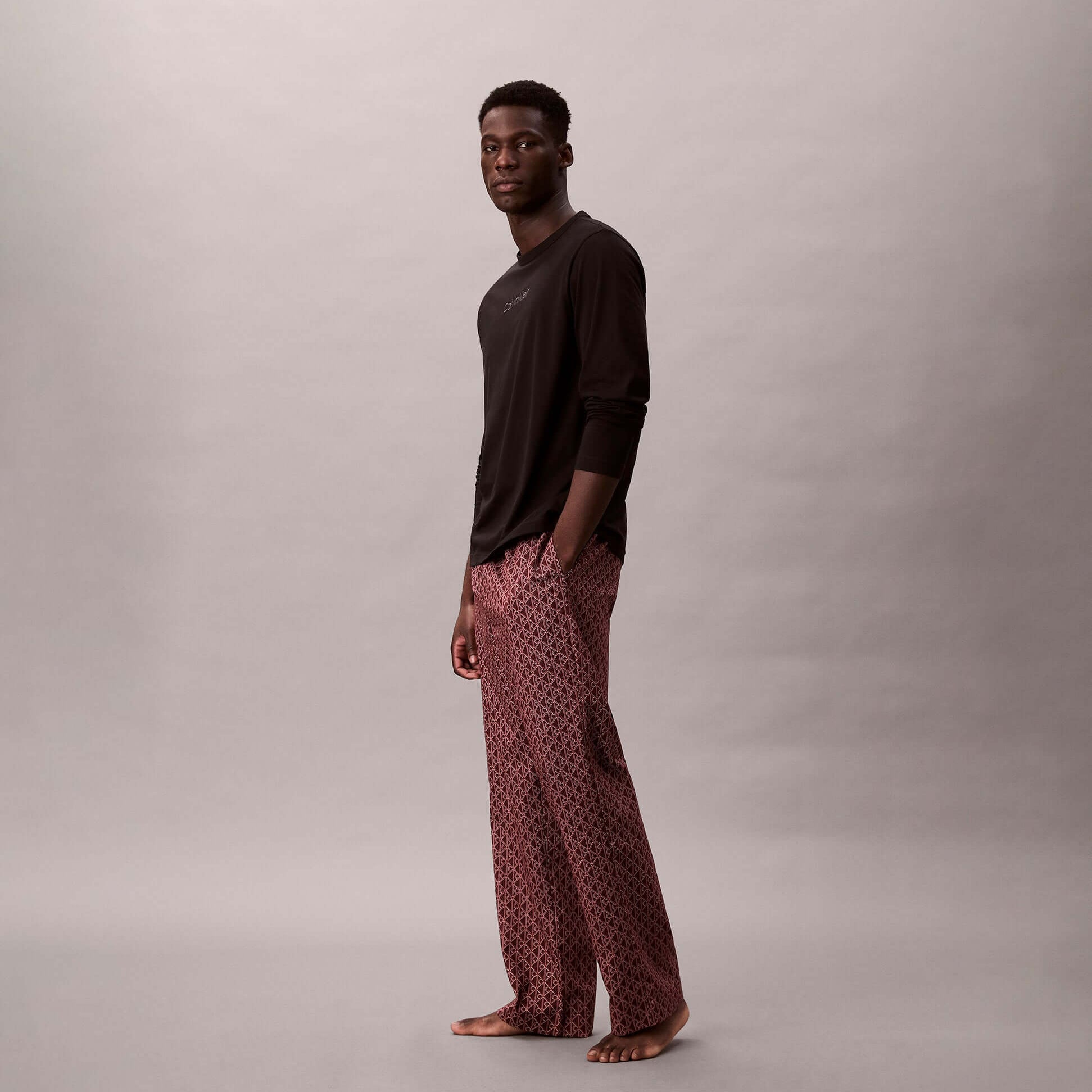 Calvin Klein LS TEE PANT SET Mens Multicoloured side view model wearing black long-sleeve tee and patterned pants.