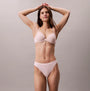 Calvin Klein Bonded Flex Seamless Womens 3 Pack Thong Multi model displaying light pink thong and bra, front view.