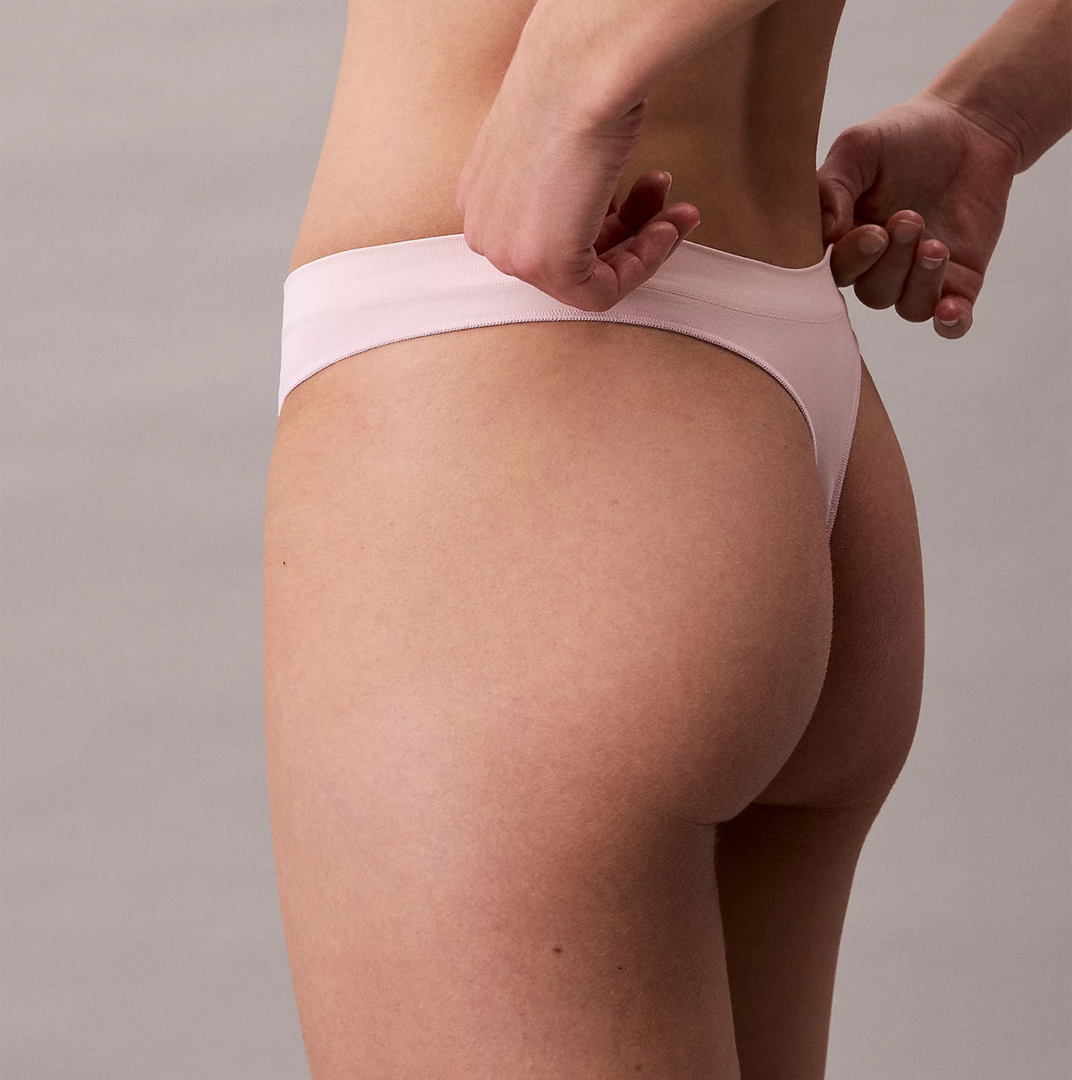 Calvin Klein Bonded Flex Seamless Womens 3 Pack Thong Multi side view of thong on model, highlighting soft fabric and fit.