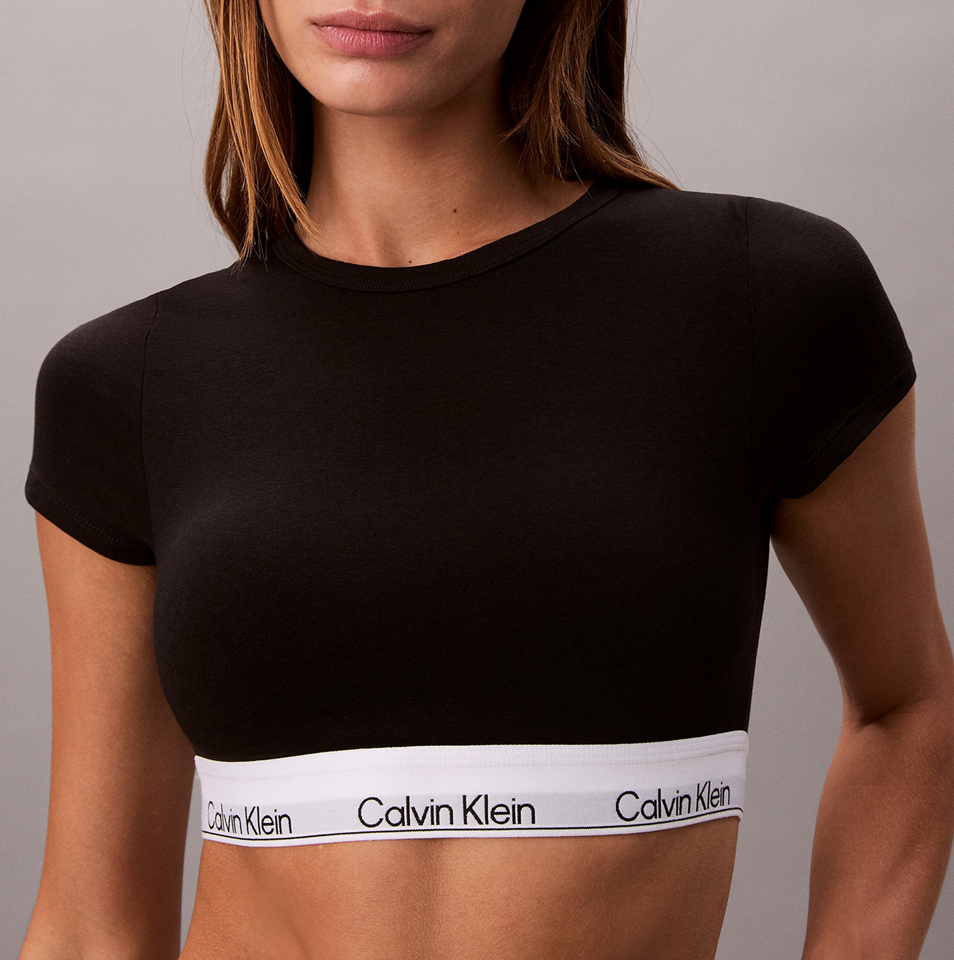 Calvin Klein T-SHIRT BRALETTE Womens Black front view showcasing the soft fabric and signature logo band.