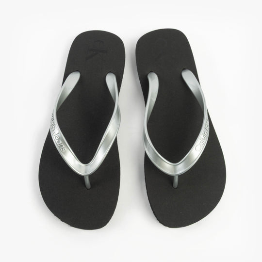 Calvin Klein BEACH SANDAL MONOLOG Womens Sandals Black/Silver top view showcasing the flat design and silver accents.