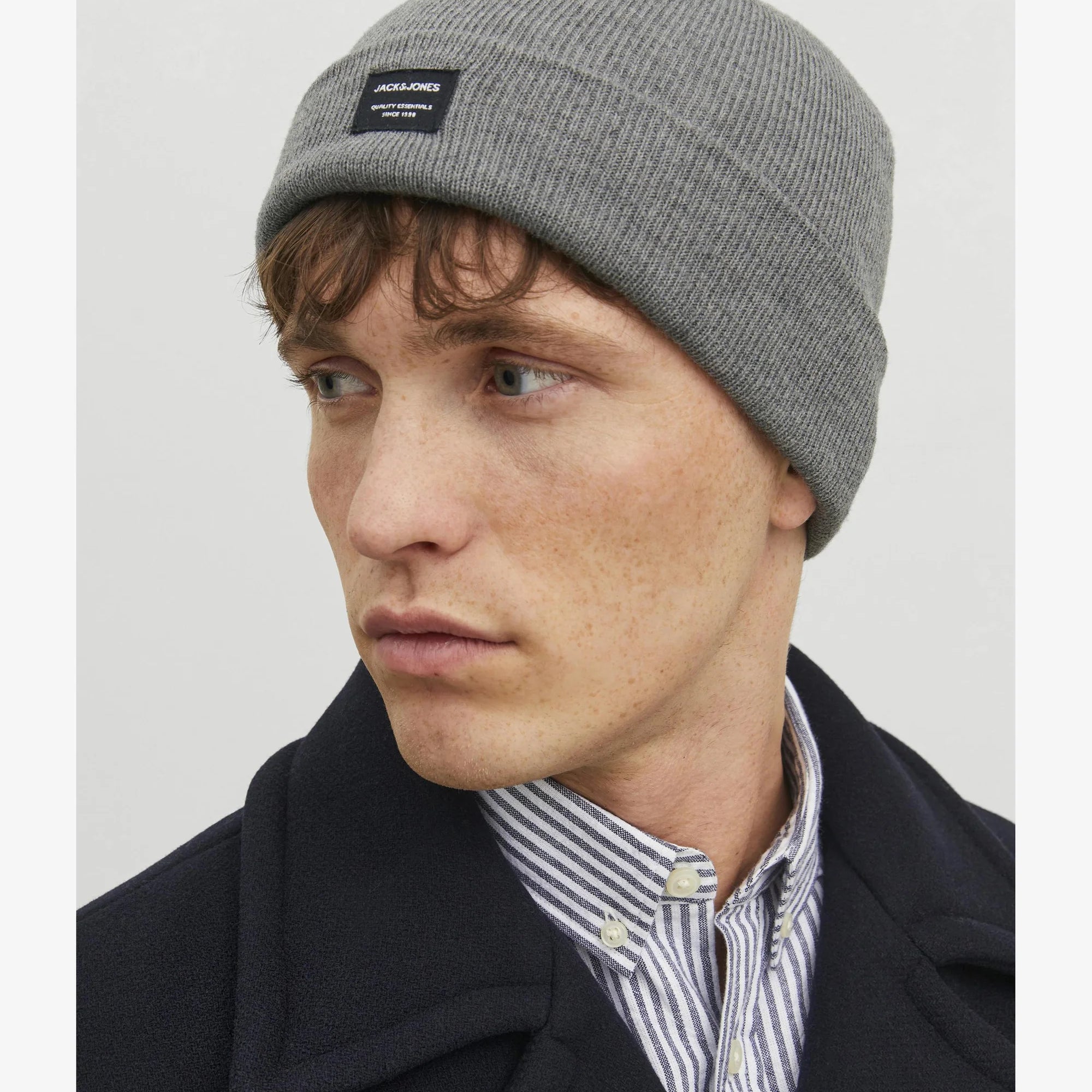 Jack & Jones DNA Mens Beanie Grey Melange worn by a model in profile view, showcasing its comfortable fit and stylish design.
