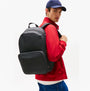 Tommy Hilfiger REPREVE Metal Logo Backpack Black side view worn by model in casual outfit.