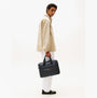 Tommy Hilfiger Signature Laptop Bag Navy side view, held by a model, showcasing its stylish design and color.
