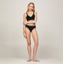 Tommy Hilfiger TH ORIGINAL LOGO BIKINI Womens Briefs Black front view on model, showcasing stretch cotton and TH logo waistband.